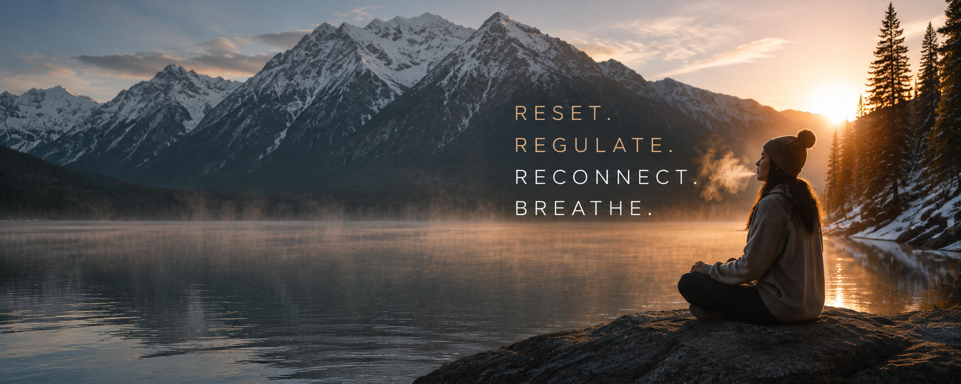 A person meditates by a misty lake at sunrise, with snow-capped mountains in the background